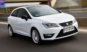 Biały Seat Ibiza 1.4 benzyna w ruchu, z czarnym dachem, na drodze.