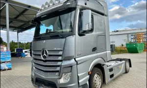 Srebrny Mercedes Actros MP4 z pięcioma halogenami na dachu, gotowy do trasy.