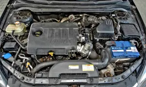 Silnik Kia Ceed 1.6 CRDi. Widoczny jest czarny plastikowy kolektor, akumulator Bosch i zbiornik płynu chłodniczego.