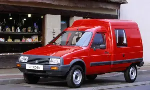 Czerwony Citroen C15, dostawczy klasyk, parkuje przed sklepem z upominkami.