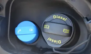 Dwa korki wlewu paliwa: jeden niebieski z symbolem płynu i książki, drugi czarny z napisem "Diesel" i symbolami. Dowiedz się, adblue co to jest i do czego służy.