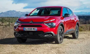Czerwony Citroën C4X na tle górskiego krajobrazu.