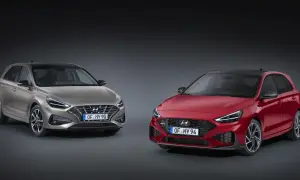 Dwa modele Hyundai i30 2024: jeden w kolorze złotym, drugi w czerwonym, prezentują nowoczesny design i sportowe linie.