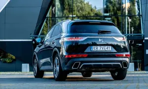 Elegancki czarny Citroën DS7 Crossback z polskimi tablicami rejestracyjnymi stoi przed nowoczesnym budynkiem.