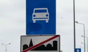 Znak drogowy ekspresowy z symbolem samochodu i znak końca drogi ekspresowej z sylwetką miasta.
