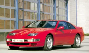 Czerwony Nissan 300zx z lat 90. stoi przed budynkiem z dużymi, przeszklonymi drzwiami.