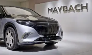 Elegancki Maybach błyszczy na tle logo marki. Poznaj jego wyjątkową **maybach cena** i poczuj luksus.