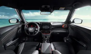 Wnętrze tivoli auto z widokiem na plażę i ocean. Czarne fotele z pomarańczowymi przeszyciami, nowoczesna deska rozdzielcza.