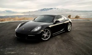 Czarny Porsche GTS na tle gór i jeziora.