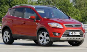 Czerwony Ford Kuga na parkingu. Kierowca w środku. Wiele osób szuka ford kuga opinie przed zakupem.