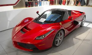 Czerwone Ferrari LaFerrari z czarnym dachem, błyszczące w salonie, gotowe do jazdy.
