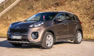 Brązowy Kia Sportage 2020 zaparkowany na drodze, z widocznymi schodami w tle.