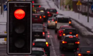 Czerwone światło na sygnalizatorze drogowym. Stojący w korku kierowcy powinni uważać, by nie dostać mandatu za czerwone światło.