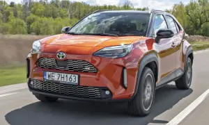 Pomarańczowy Toyota Yaris Cross GR Sport na drodze. Sprawdź aktualną toyota yaris cross cena i dostępne wersje.