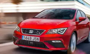 Czerwony Seat Leon 2025 pędzi po drodze, jego sportowy design przyciąga wzrok.