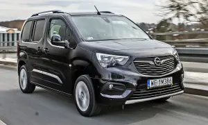 Czarny Opel Combo Life pędzi po drodze, gotowy na rodzinne przygody.
