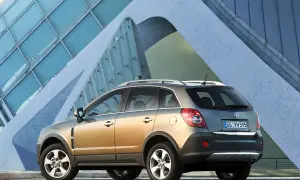 Złoty Opel Antara z nowoczesnym budynkiem w tle.