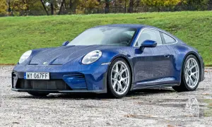 Niebieski Porsche 911 na mokrej nawierzchni. Zastanawiasz się nad porsche 911 cena?
