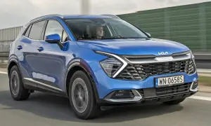 Nowa Kia Sportage w kolorze niebieskim jedzie po drodze.