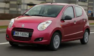 Czerwony Suzuki Alto z polskimi tablicami rejestracyjnymi WB 1606C jedzie po drodze.