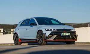Sportowy Hyundai Ioniq 5 N z czerwonymi akcentami i czarnymi felgami na tle betonowego muru i błękitnego nieba.