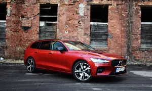 Czerwone Volvo V60 na tle starej ceglanej ściany. Wiele osób szuka volvo v60 opinie, ten model wygląda świetnie.