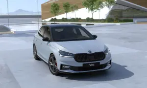 Nowa Skoda Fabia 2026 w jasnym kolorze z czarnym dachem, zaparkowana przed nowoczesnym budynkiem.