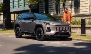 Nowy Toyota RAV4 2025 cena: stylowy SUV ładowany przy miejskiej stacji.