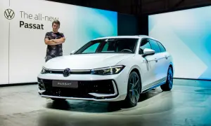 Mężczyzna stoi obok białego kombi, prezentując nowy Passat 2024.