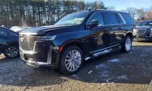 Czarny Cadillac Escalade 2025 z chromowanymi felgami i detalami, zaparkowany na żwirowym placu z resztkami śniegu.