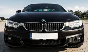 Czarny BMW F32 435i z błyszczącą atrapą chłodnicy i ostrymi reflektorami, gotowy do jazdy po krakowskich ulicach.