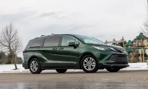 Zielona Toyota Sienna zaparkowana obok placu zabaw.