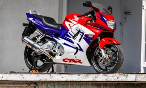 Czerwono-biało-niebieski motocykl sportowy Honda CBR 600 na stojaku.