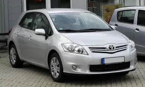 Srebrny Toyota Auris 1.6 benzyna zaparkowany na kostce brukowej.