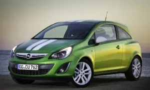 Zielony Opel Corsa D 1.2 benzyna z białymi pasami na masce, zaparkowany przy plaży.