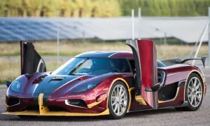 Czerwony Koenigsegg Agera RS z otwartymi drzwiami, gotowy do startu na tle paneli słonecznych.