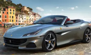 Srebrny Ferrari Portofino z czerwonym wnętrzem na tle kolorowych budynków nad wodą.