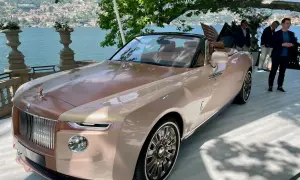 Elegancki Rolls-Royce Boat Tail w kolorze szampańskim, prezentowany nad jeziorem Como, przyciąga wzrok swoim unikalnym designem.