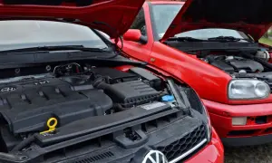 Dwa czerwone Volkswageny z otwartymi maskami. Widać silnik TDI, czyli silnik diesla, w nowszym modelu i starszy silnik w Golfie III.