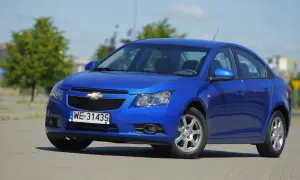 Błękitny Chevrolet Cruze 1.8 benzyna zaparkowany na placu.
