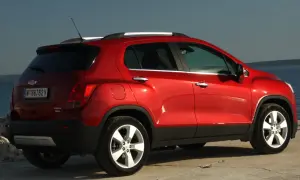 Czerwony Chevrolet Trax z tablicą rejestracyjną W 88762 V stoi nad morzem.