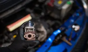 Zardzewiały zawór EGR w dłoni mechanika. Zastanawiasz się egr co to? To kluczowy element układu recyrkulacji spalin.