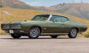Zielony Pontiac GTO z 1969 roku na tle wzgórz. Klasyk amerykańskiej motoryzacji.