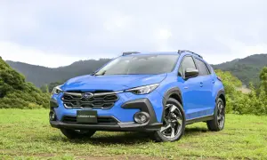 Niebieski Subaru XV Crosstrek na tle zielonych wzgórz. Gotowy na przygodę w terenie.