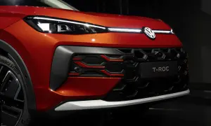 Pomarańczowy Volkswagen T-Roc z nowoczesnymi światłami IQ.LIGHT i charakterystycznym grillem.