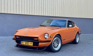 Pomarańczowy Datsun 280Z z lat 70. na tle budynku. Klasyk motoryzacji gotowy na przejażdżkę.