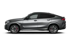 Srebrne BMW X6M z przyciemnianymi szybami i sportowymi felgami, gotowe do dynamicznej jazdy.
