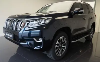 Ciemnogranatowy Land Cruiser Prado z chromowanym grillem i reflektorami LED, gotowy na każdą przygodę.