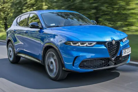 Niebieskie Alfa Romeo Tonale pędzi po drodze, zachwycając dynamicznym designem. Sprawdź aktualną alfa romeo tonale cena i poczuj włoską pasję.