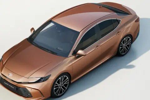 Nowy Toyota Camry 2025 cena: stylowy, miedziany sedan hybrydowy z nowoczesnym designem.